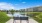 a bench in front of a pond with a building in the background