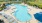 a pool with lounge chairs around it